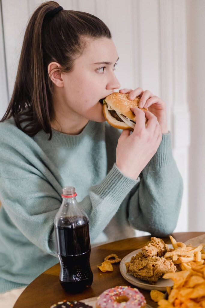 Chica comiendo comida basura propiciando un efecto rebote